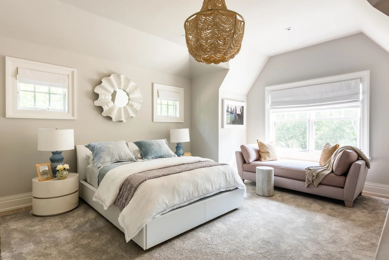A guest bedroom of a Watermill New York home by Downey was designed in a palette of soft hues of gray blue and blush and...