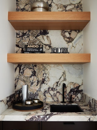 A coffee bar sits between the primary suite and office and is offset with a striking marble. “We found a lovely Breccia...