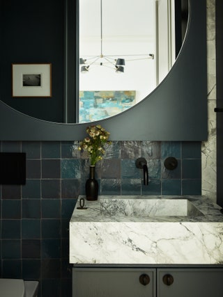 Enger chose a “honed superwhite” Calacatta marble for the powder room. A Kallista wallmount faucet sits above the sink.
