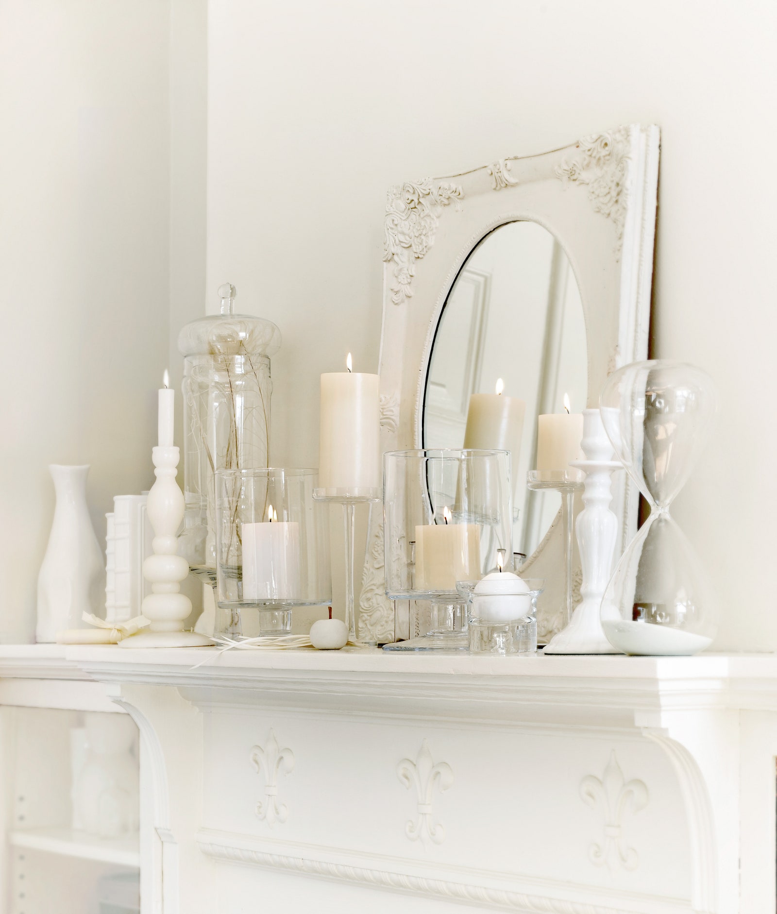 White candles mirror candlestick holders white vases on a white mantel