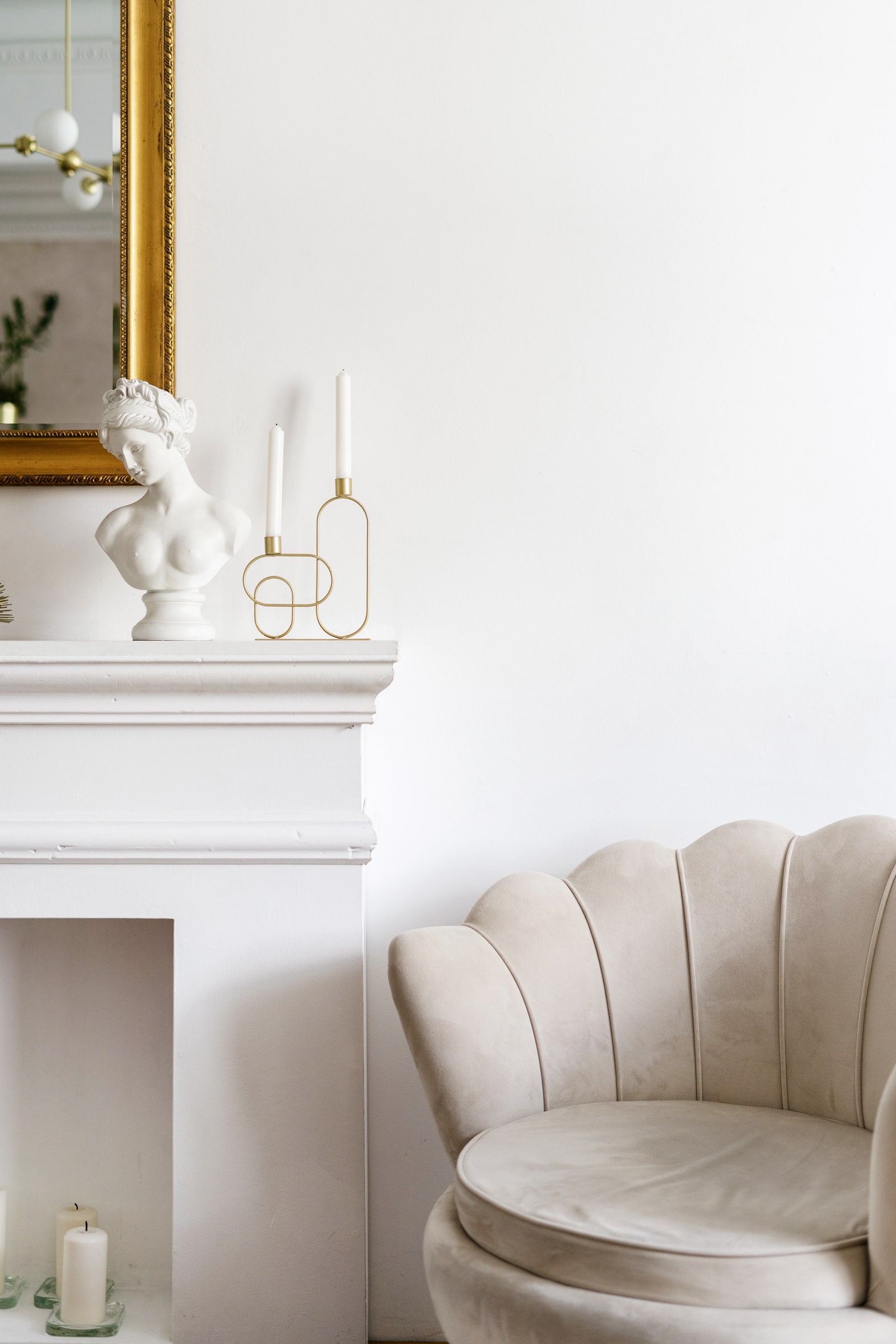 Modern candlestick holders mixed in with an antiquelooking bust give this mantelpiece an eclectic vibe.