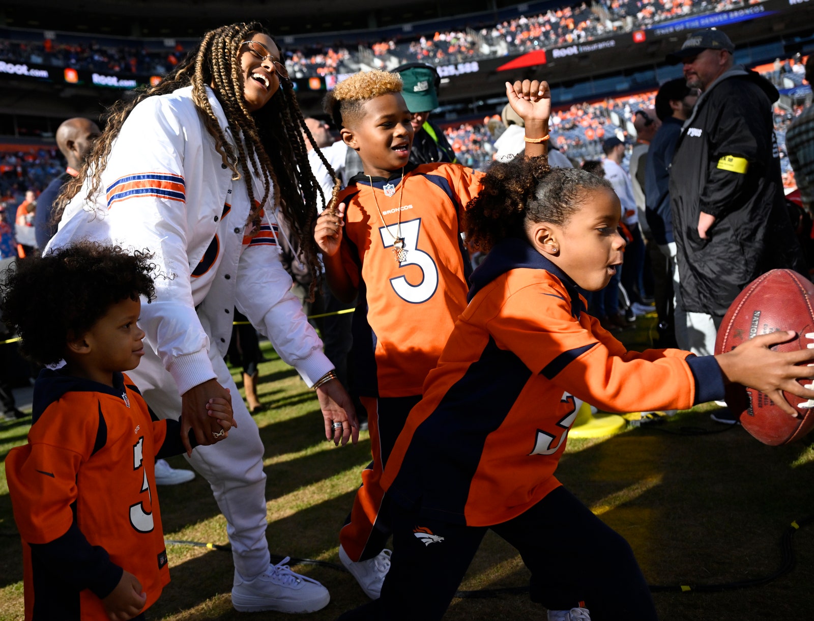 Ciara with sons Future and Win and daughter Sienna on field at Broncos game