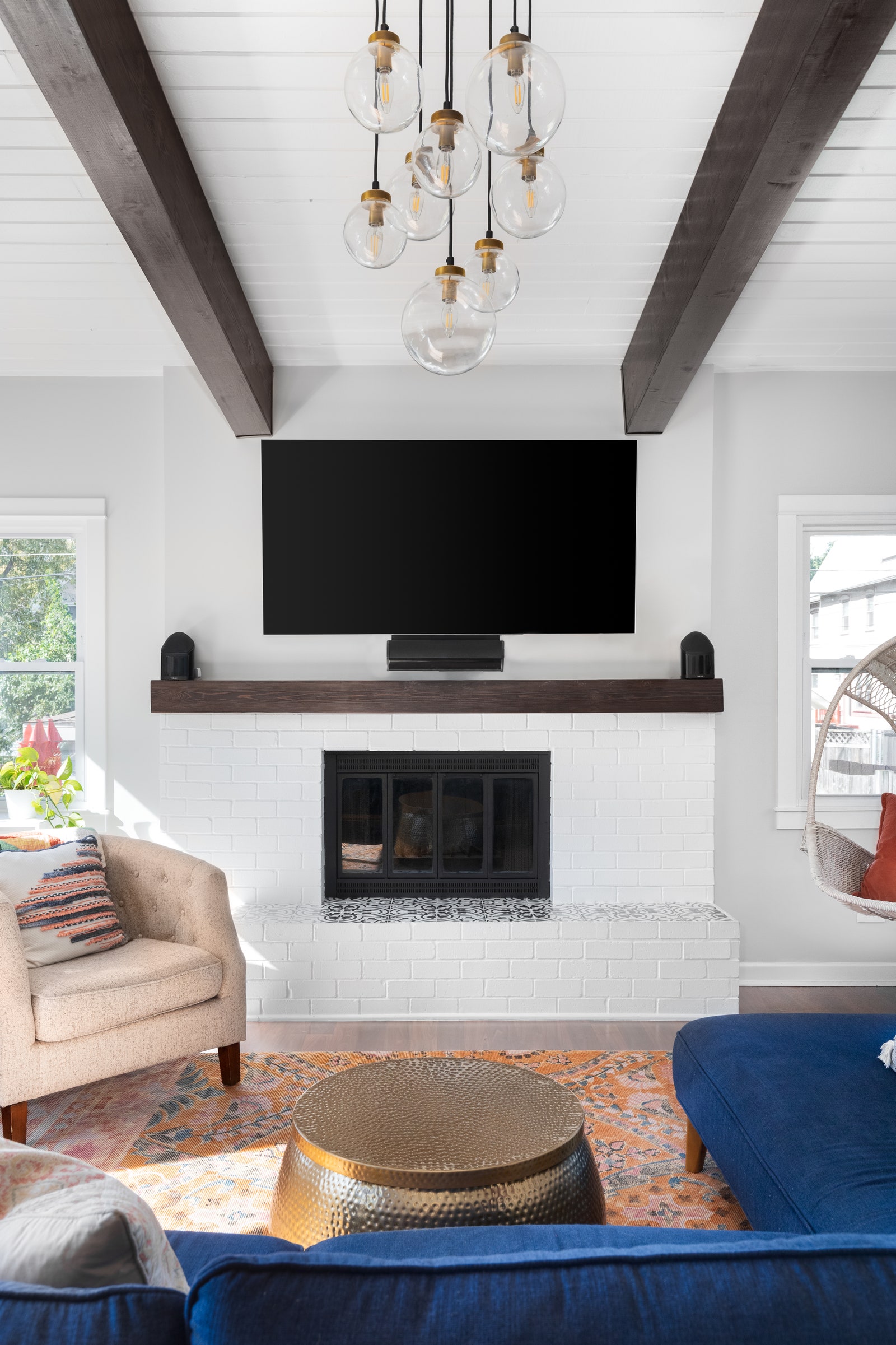 tv above mantel in white living room